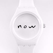 White watch with "now" written in black on the center of the watch's face.